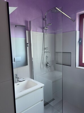 A modern bathroom with a glass shower enclosure, a white sink, and a mirror. - Fabulous 11-bedroom hotel in Heart of Shkodër.AC ,High-speed Wi-Fi.Comfort,style (Shkodër)