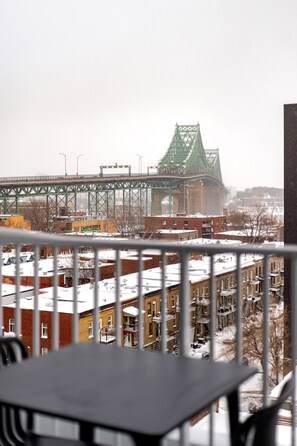 A view of a green bridge, residential buildings, and a snow-covered roof. - Montreal Retreat with Rooftop Pool & Parking (Montreal)