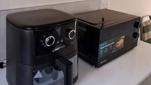 A kitchen with a coffee maker, a toaster, and a microwave on the counter. - Luxury Guest Apartment Fully Furnished With all Amenities (Pretoria)
