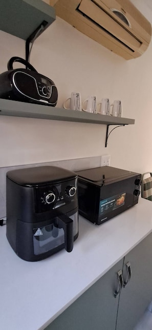 A kitchen with a coffee maker, a toaster, and a microwave on the counter.