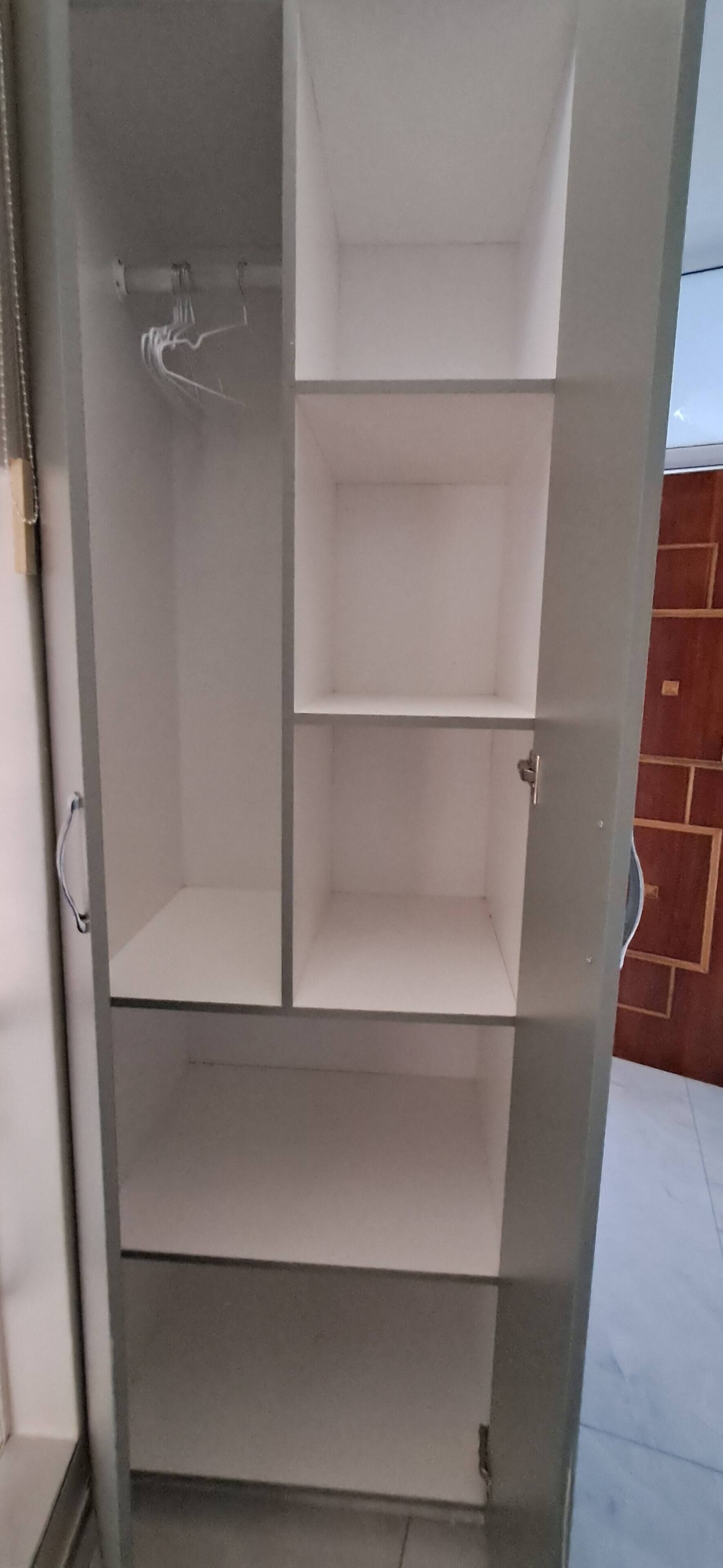 Une pièce avec une armoire, une porte et un mur en briques.