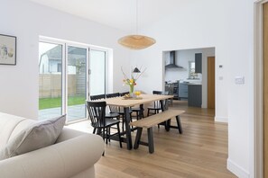 Una cocina moderna con comedor, un ventanal grande y piso de madera.
