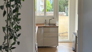 Eine Küche mit Holzarbeitsplatte, Spüle und Fenster mit Blick auf einen Garten.