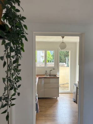 A kitchen with a wooden countertop, a sink, and a window overlooking a garden. - Bright family apartment in Aix-en-Provence (Aix-en-Provence)