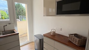 Eine moderne Küche mit eingebautem Backofen, einer Spüle und einem Fenster mit Blick auf einen Garten.