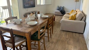 Ein Essbereich mit einem Holztisch, Stühlen und einem an der Wand befestigten Fernseher.