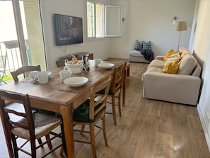 A dining area with a wooden table, chairs, and a television mounted on the wall. - Bright family apartment in Aix-en-Provence (Aix-en-Provence)