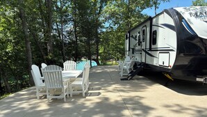 A recreational vehicle with a dining area featuring a table and chairs. - Gated Luxury Glamping at Diamond Acres – Near Grove Marina & Cumberland Falls (Corbin)