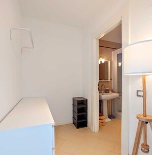 A narrow hallway with a white cabinet, a small black storage unit, and a doorway leading to a bathroom with a sink and mirror. - BEst16 Relax&SeaView. Seafront, with covered parking space. (SAN LORENZO AL MARE)