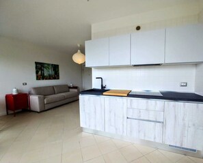 A modern kitchen with white cabinetry, a black countertop, and a pendant light. - BEst16 Relax&SeaView. Seafront, with covered parking space. (SAN LORENZO AL MARE)