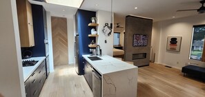 Eine moderne Küche mit einer eingebauten Kochinsel, einem Kühlschrank und einer Mikrowelle.