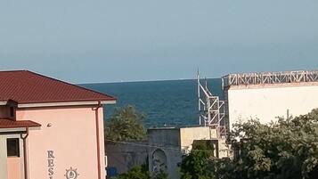 A building with a sign reading 'RESIDENCE ANDREA' and a view of the sea in the background.