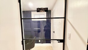 A door with a sign reading 'Le Chatou Office' leading to a room with a chair and a tiled floor. - Luxe 3BR with 3 Private Bathrooms Near Airport and 30 mins to NYC (Newark)