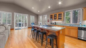 Una cocina amplia con una isla grande, armarios de madera y lavavajillas de acero inoxidable.