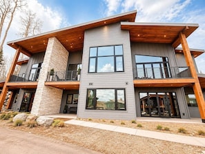A modern two-story house with a stone facade, large windows, and a wooden deck. - Ski-In/Out Brian Head | Sauna, Game Room & Views (Brian Head)