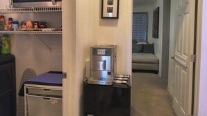 Une cuisine compacte équipée d’un four à micro-ondes, d’une machine à café et d’un petit réfrigérateur.