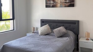 A modern bedroom with a large bed, two bedside tables, a nightstand, and a painting on the wall. - Apartment near the airport with pool and office all inclusive (Cancún)
