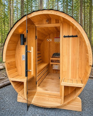 Un sauna en bois doté d’un toit incurvé, d’un banc, d’un appareil de chauffage et d’un panneau de commande.