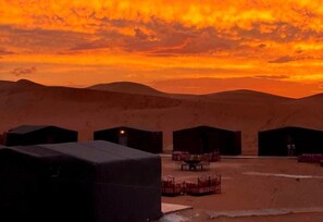 A desert landscape with tents and tables set up, likely for accommodation or events. - Desert Erg Chigaga (M'Hamid El Ghizlane)