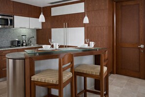 Een moderne keuken met een centraal eiland, roestvrijstalen apparatuur en houten keukenkastjes.