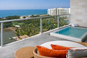 A balcony with a view of the ocean, a swimming pool, and a wicker chair with cushions. - Luxury Retreat at The Grand Mayan – Nuevo Nayarit (Nuevo Vallarta)
