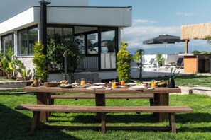Ein Holztisch-Set für ein Picknick draußen, im Hintergrund ein modernes Gebäude.