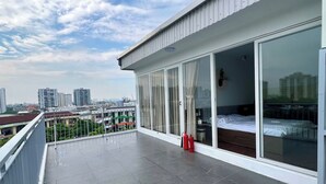 A balcony with a view of the city, a bed, and a fire extinguisher. - Compact Studio w/ Projector & Sky View (Hà Nội)
