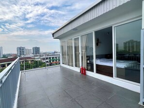 Varanda com vista para a cidade, uma cama e um extintor de incêndio.
