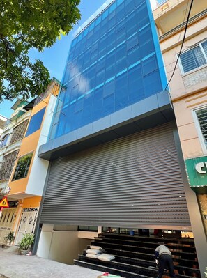 En moderne bygning med en glasfacade, lukket lukket indgang og en trappe der fører ned til stueplan.