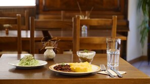 A dining table with plates of food, a glass of water, and cutlery. - Les Lilas Apartment (2–4 people) (BASSURELS)