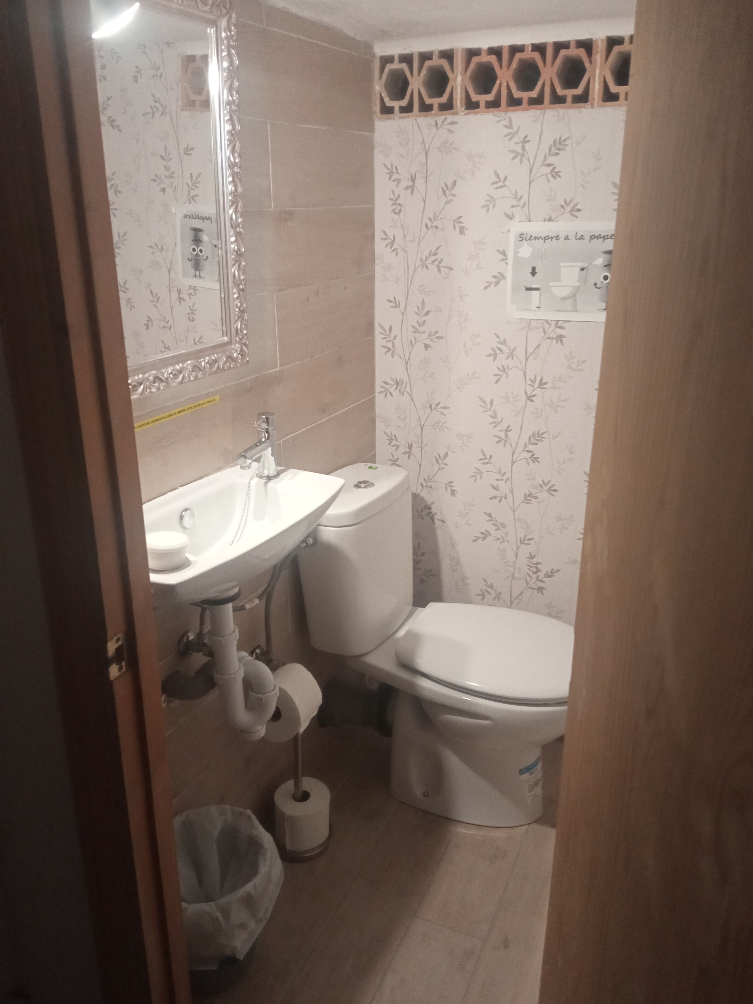 A bathroom with a sink, toilet, and mirror.