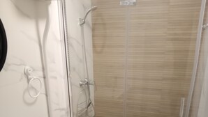 Een badkamer met toilet, wastafel en douche.