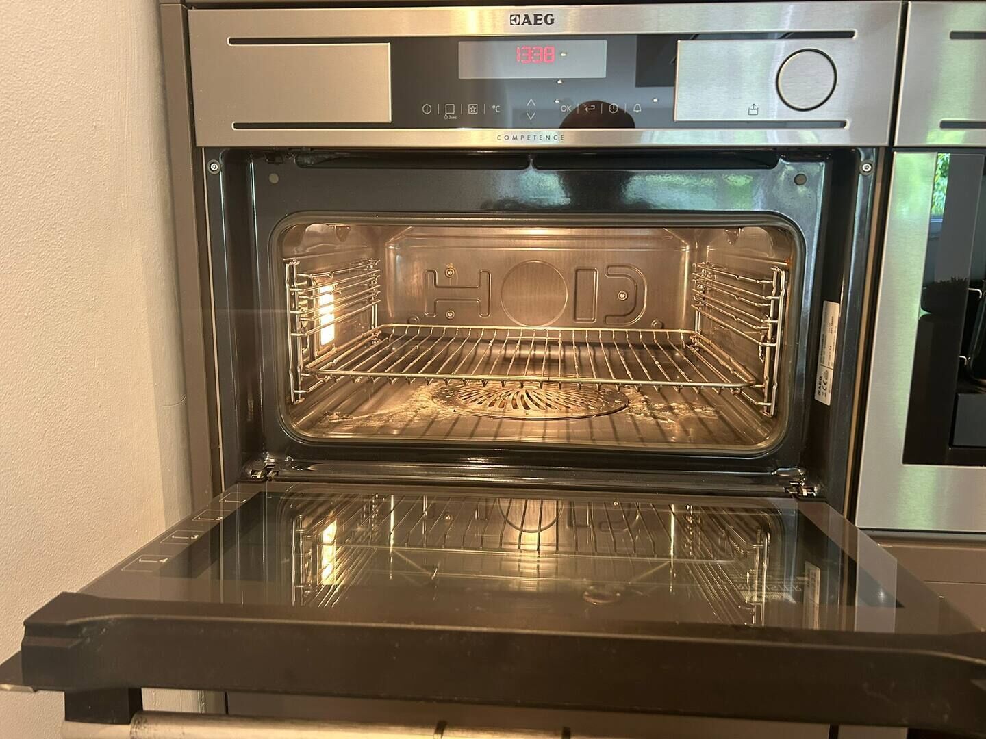 An oven with a digital display, a control panel, and a rack inside.