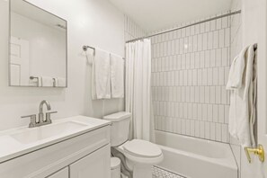 A bathroom with a white sink, toilet, and bathtub, and a shower curtain. - Route 66/Grand Canyon Retreat, Central Williams, Family-friendly, Sleeps 8 (Williams)