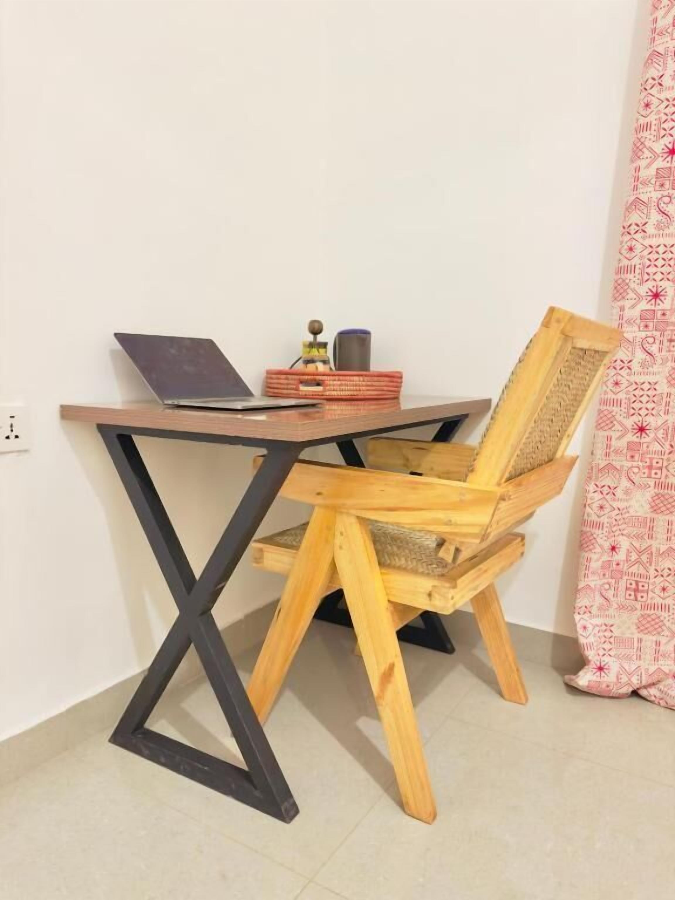 A wooden desk with a laptop, a small decorative item, and a basket.