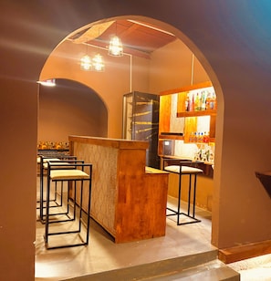 A bar area with wooden furniture, a counter, and a display of bottles. - Kaduwa Imperial Hotel (Lilongwe)