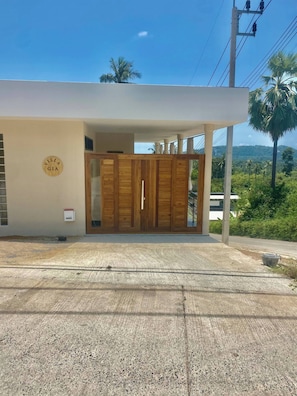 A modern building with a wooden door and a sign that reads 'Villa Gia.' - Romantic Tropical Villa Retreat in Maret, Thailand (Koh Samui)