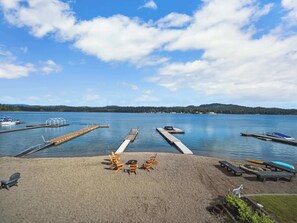 A lakeside dock with wooden chairs and a boat. - Little Hamptons on The Lake (Newport)