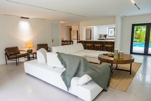 Un salon moderne avec un canapé blanc, une table basse et une lampe.