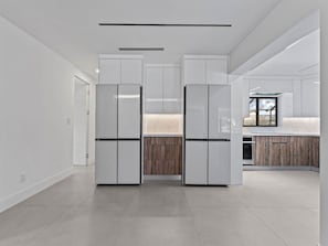 Eine moderne Küche mit weißen Schränken, einer Holz Arbeitsplatte und einem eingebauten Backofen.