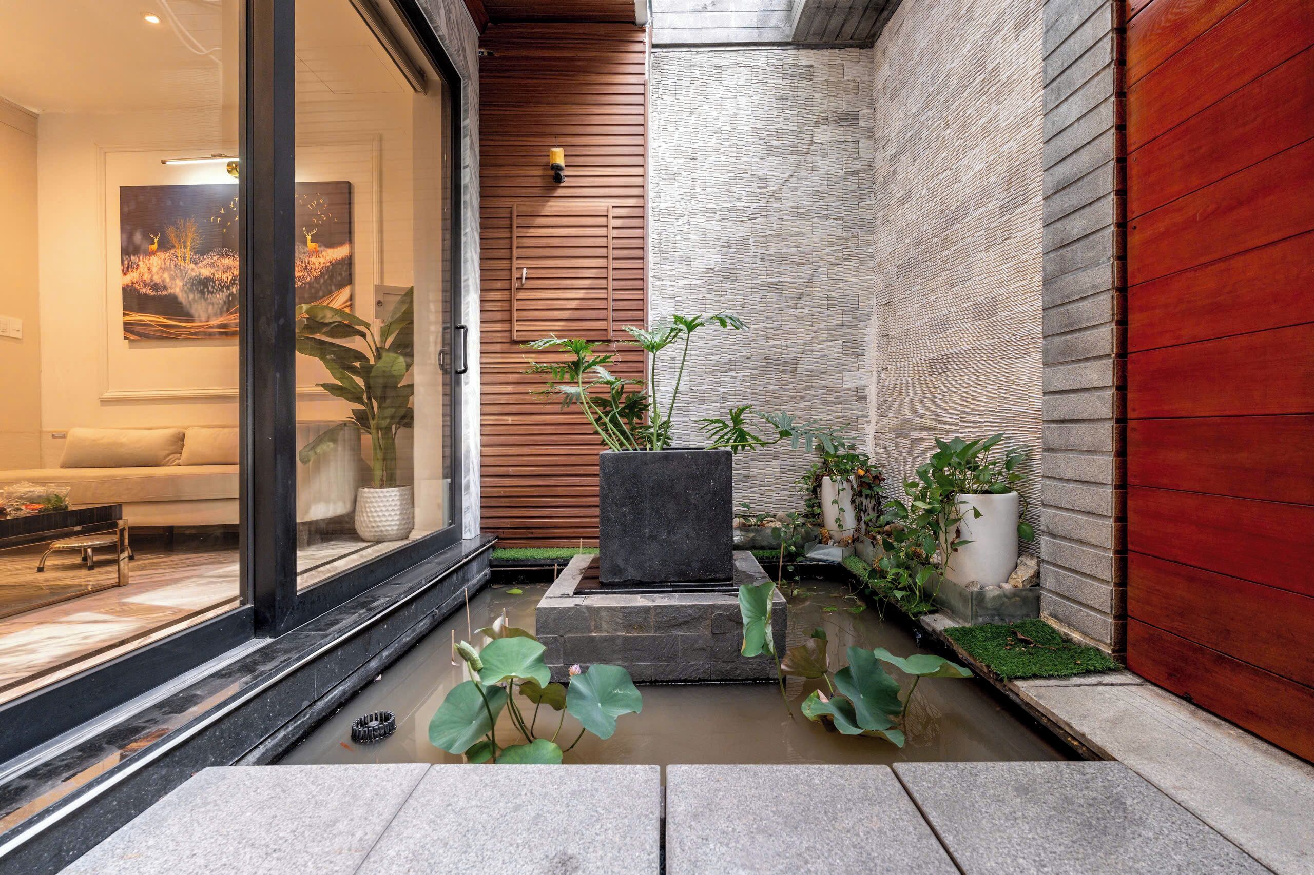 A modern interior with a stone planter, a wooden wall, and a glass door.