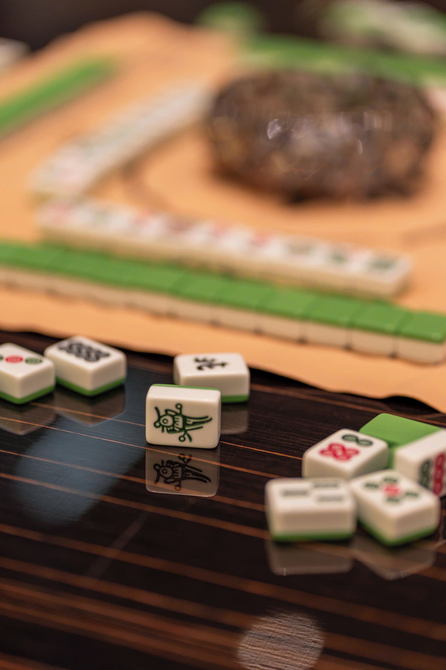 A close-up of a mahjong tile set on a wooden surface.