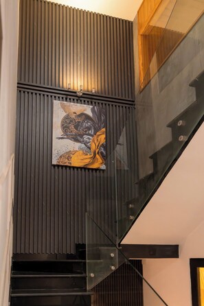 A modern interior with a staircase, a wall-mounted artwork, and a wooden slat design. - Tropical Pool Villa D1 with 5 bedrooms (Tan Dinh)