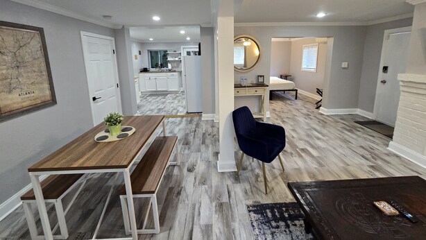 A modern interior with a dining area, a seating area, a kitchen, and a bedroom.
