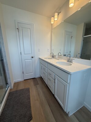 Un bagno con due lavandini, uno specchio grande e una doccia.