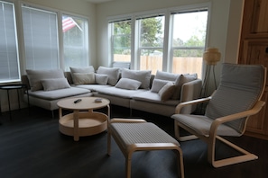 A living room with a sectional sofa, a round coffee table, a cushioned bench, and a chair.