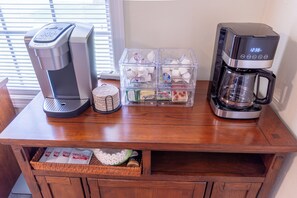 A wooden table with a coffee maker, a Keurig coffee machine, and a basket of coffee pods. - 3Bdrm / Game Room Home / World Cup / 15 Min to NRG / 5 Min from Hobby Airport (Houston)