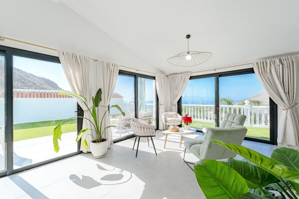 Ein geräumiger Balkon mit Meerblick, ein helles Interieur mit moderner Möbel und große Fenster.