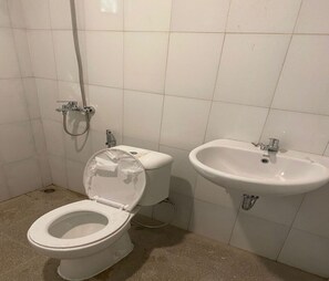 A bathroom with a toilet, a bidet, and a sink.