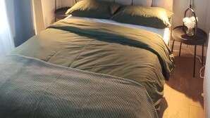 A bedroom with a bed, two bedside lamps, a framed picture on the wall, and a window with curtains. - Apartment in Belfast City (3) (Belfast)